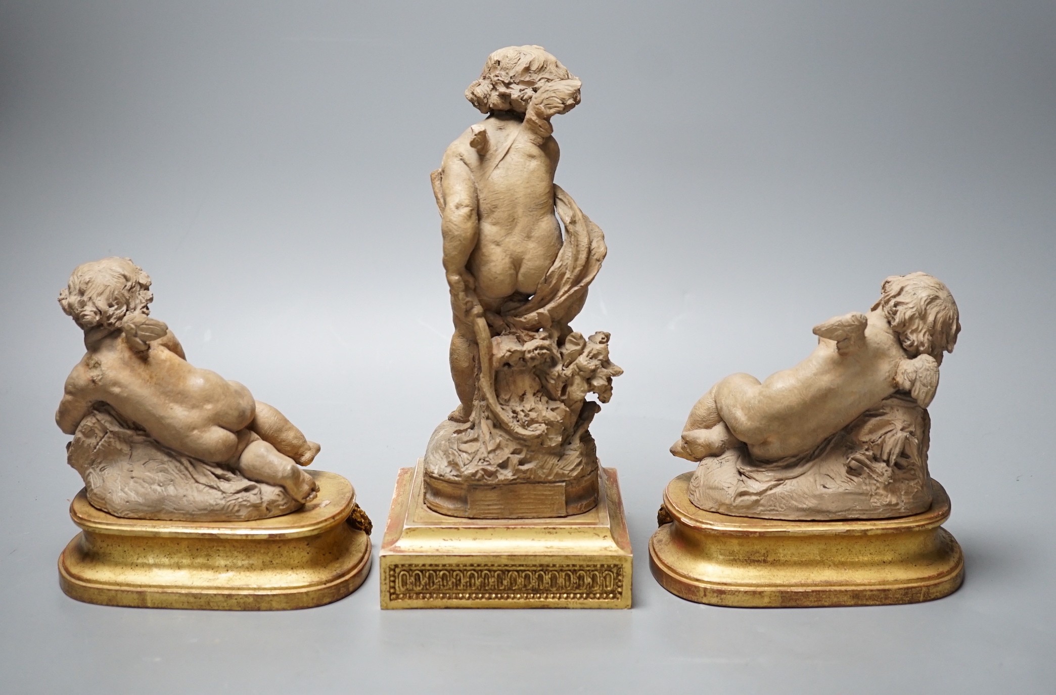 Two 19th century French terracotta cherubs and one other Cupid, after Clodion, all on giltwood stands, tallest 23.5cm